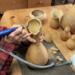This shows me carving a vase rim into the top of a dried gourd.
